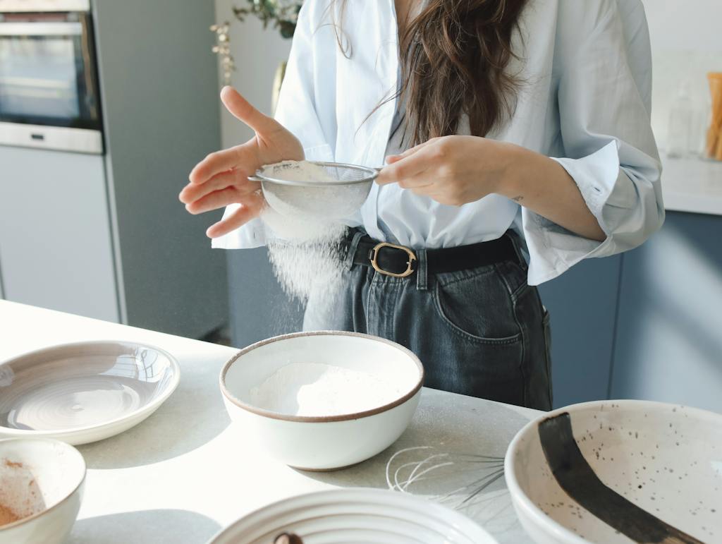 A Person Sifting Flour