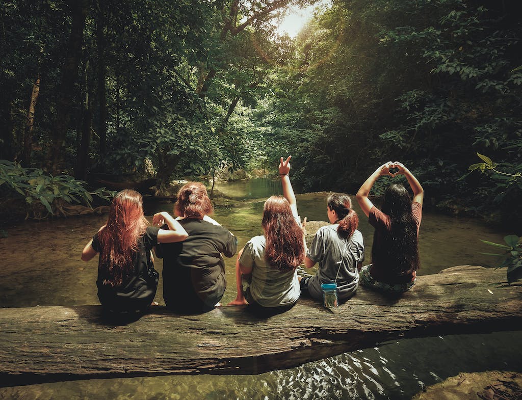 Five Women Sitting On Tree Trunk - adventurous to build close friendships